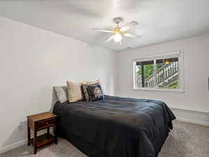 Bedroom with light carpet and a ceiling fan