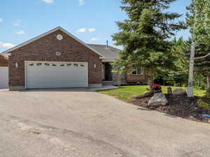 View of front facade featuring brick siding, concrete driveway, and a garage