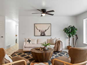 Living room featuring a ceiling fan and light tile patterned floors