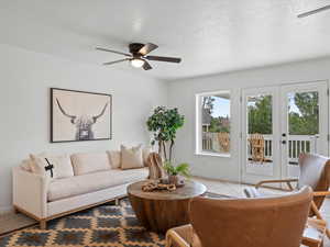 Living room featuring a ceiling fan, french doors, and a textured ceiling
