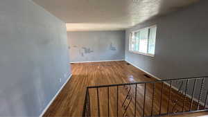 Unfurnished room featuring a textured ceiling and wood finished floors