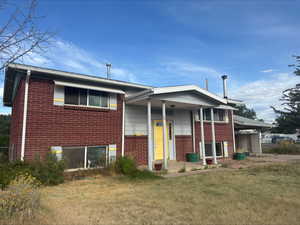View of front of property with brick siding and a front yard