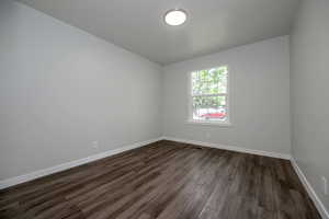 Unfurnished room with dark wood-style floors and baseboards
