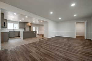 Unfurnished living room with wood finished floors, plenty of natural light, and recessed lighting