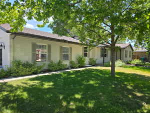 Ranch-style house with brick siding, a front yard, and a shingled roof
