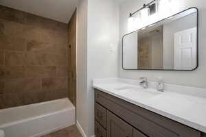 Bathroom with vanity, tile patterned flooring, and bathing tub / shower combination
