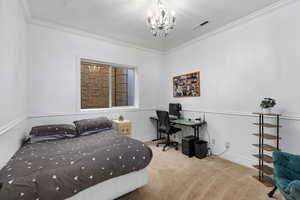 Bedroom featuring ornamental molding, a chandelier, light colored carpet, an office area, and a wainscoted wall