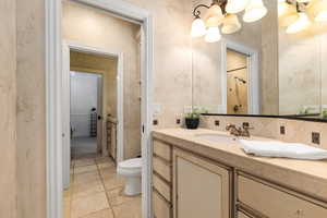 Full bath featuring vanity, stone tile floors, and a shower