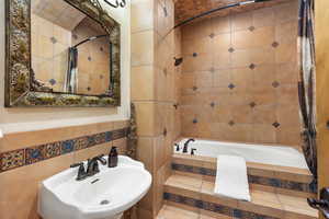Bathroom featuring tile walls and tiled shower / bath