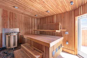 Relaxing sauna featuring wooden ceiling and wood walls