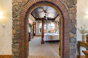 Unfurnished bedroom with arched walkways, crown molding, and carpet floors