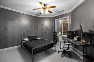 Bedroom with light colored carpet, ornamental molding, ceiling fan, and a desk