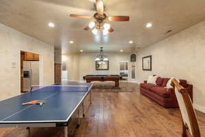 Rec room with pool table, recessed lighting, wood finished floors, ceiling fan, and a textured wall