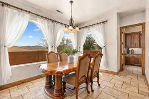 Dining area featuring stone tile flooring and hanging lights