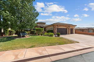 Mediterranean / spanish house with a tile roof, stucco siding, stone siding, a garage, and concrete driveway