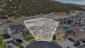 Aerial perspective of suburban area with property boundaries highlighted and mountains