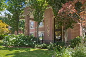 View of side of home featuring brick siding and a yard