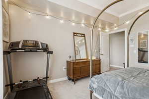 Bedroom with ornamental molding and light colored carpet