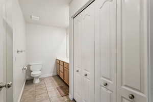 Bathroom featuring a closet, vanity, and tile patterned flooring