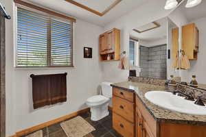 Full bath with vanity, a tile shower, and plenty of natural light