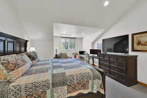 Carpeted bedroom featuring lofted ceiling and recessed lighting