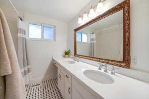 Bathroom featuring double vanity and curtained shower