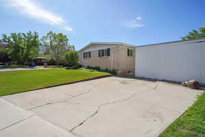 View of side of property with a yard and brick siding