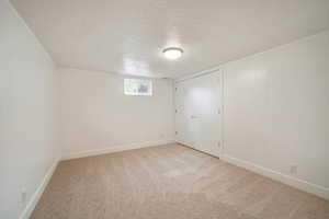 Unfurnished bedroom featuring light colored carpet and a textured ceiling