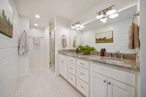 Full bathroom with double vanity, a stall shower, and recessed lighting