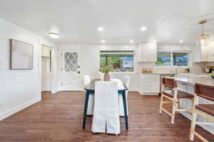 Dining room with dark wood-style floors, healthy amount of natural light, a textured ceiling, and recessed lighting