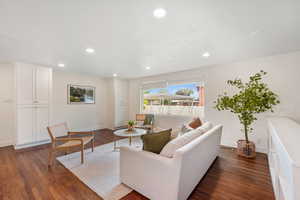 Living area featuring dark wood-style flooring and recessed lighting