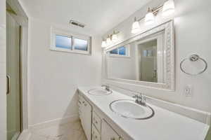 Bathroom with double vanity, a stall shower, and a textured ceiling