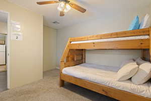 Bedroom featuring freestanding refrigerator, carpet floors, and ceiling fan