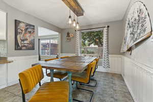 Dining space with a wainscoted wall and tile patterned flooring