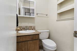 Bathroom featuring vanity and decorative backsplash
