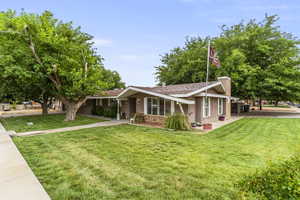 View of front facade with stucco siding, a front lawn, and a chimney