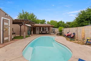 View of swimming pool with a pergola, a fenced backyard, a patio, and an outbuilding