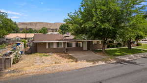 Ranch-style house featuring stucco siding, a mountain view, and a shingled roof