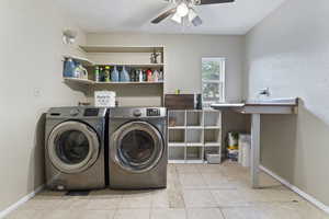 Washroom with washing machine and clothes dryer, ceiling fan, and tile patterned floors