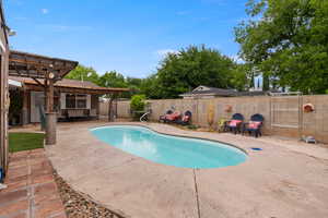 View of swimming pool with a pergola, a patio, and a fenced backyard
