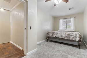 Carpeted bedroom with a ceiling fan and ornamental molding