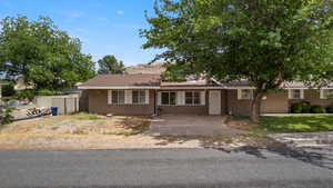Ranch-style house with stucco siding and roof with shingles