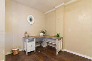 Office area featuring dark wood-style flooring and ornamental molding