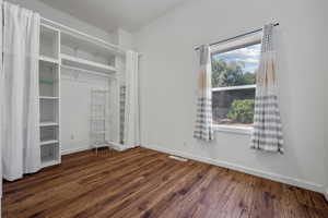 Unfurnished bedroom with multiple windows and wood finished floors