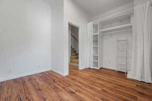 Unfurnished bedroom with dark wood finished floors and baseboards