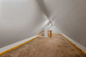 Additional living space with lofted ceiling and carpet floors