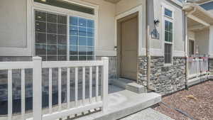 Entrance to property featuring stucco siding and stone siding