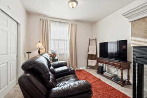 Carpeted living room with a textured ceiling