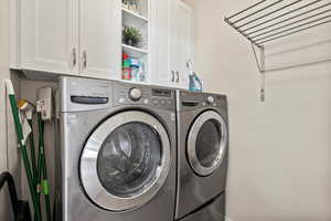 Laundry room featuring washing machine and dryer and cabinet space