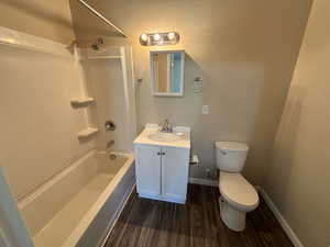 Bathroom featuring washtub / shower combination, wood finished floors, and vanity